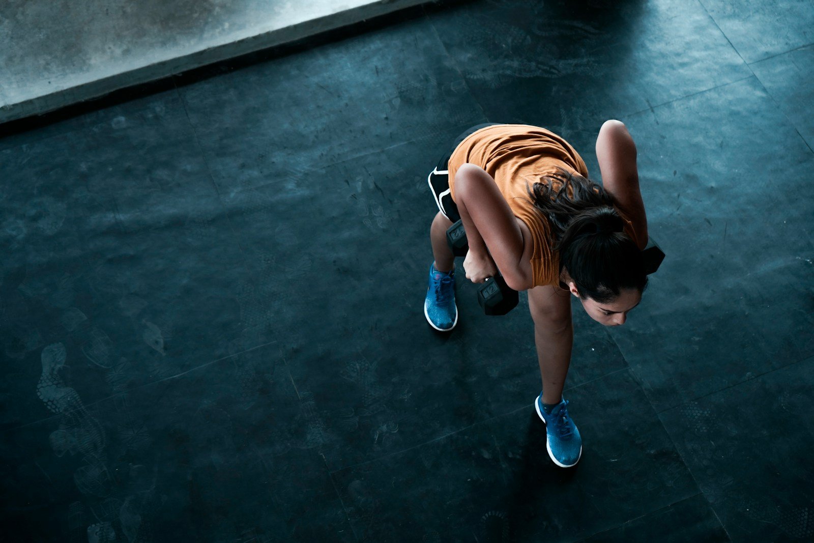 woman in orange top exercising indoors