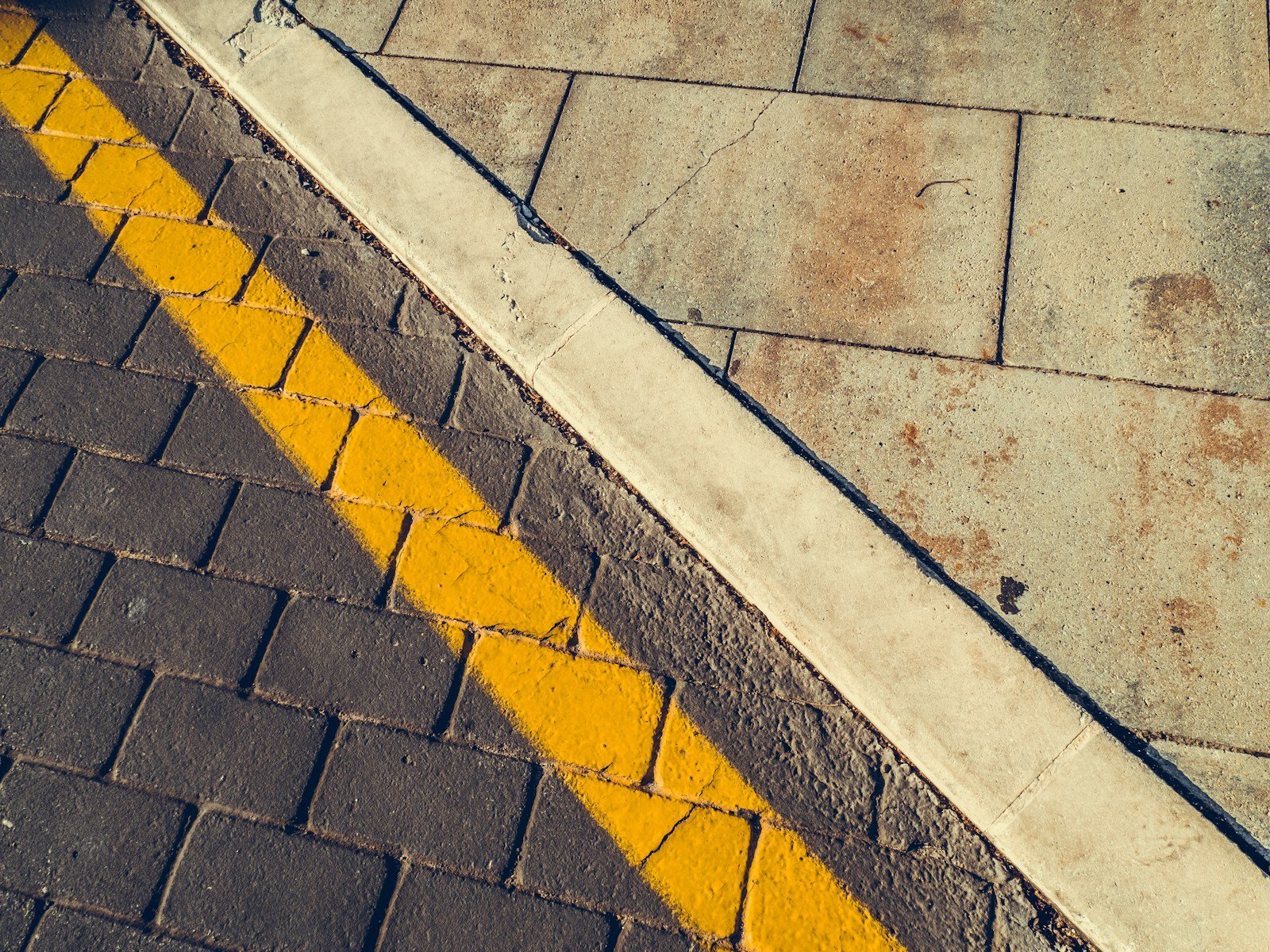 gray concrete pavement with yellow and white line boundaries